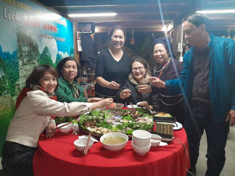 Chủ nhà và du khách cùng ăn uống tại homestay Lâm Bình này