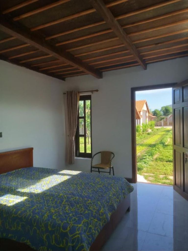 Phòng ngủ có thiết kế đơn giản, mộc mạc với view hướng ra khu vườn của villa 