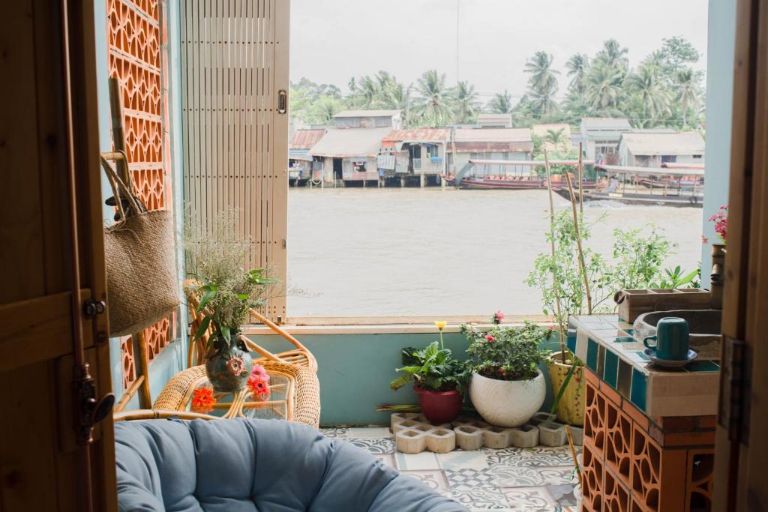 Ban công lớn trên tầng gác xép của Nam Thi homestay Tiền Giang với view rộng thoáng nhìn trcuwj diện ả bờ sông. 
