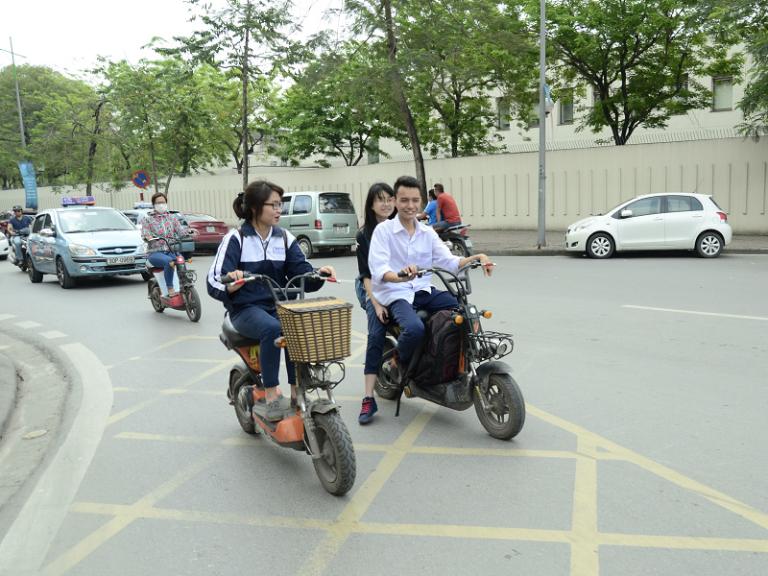 Cảnh sát giao thông nhắc nhở học sinh đi xe máy điện chưa đủ tuổi.