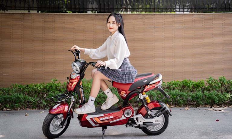 Phụ huynh hướng dẫn con tập lái xe máy điện trong sân trường an toàn