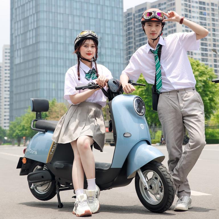 Nhóm học sinh trò chuyện bên cạnh những chiếc xe máy điện trước cổng trường