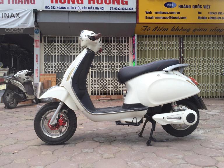 Người đi xe máy điện dùng bàn đạp trợ lực để di chuyển khi hết ắc quy giữa đường.