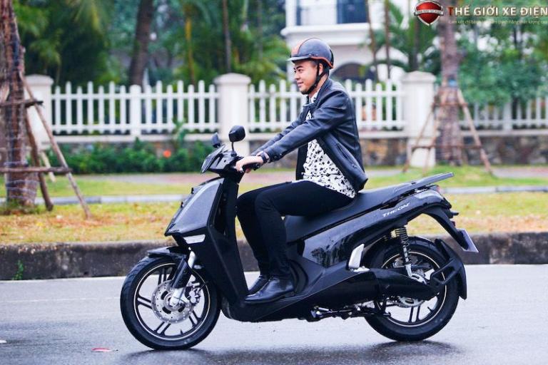 Người lái xe máy điện tốc độ cao trang bị đầy đủ mũ bảo hiểm và đồ bảo hộ