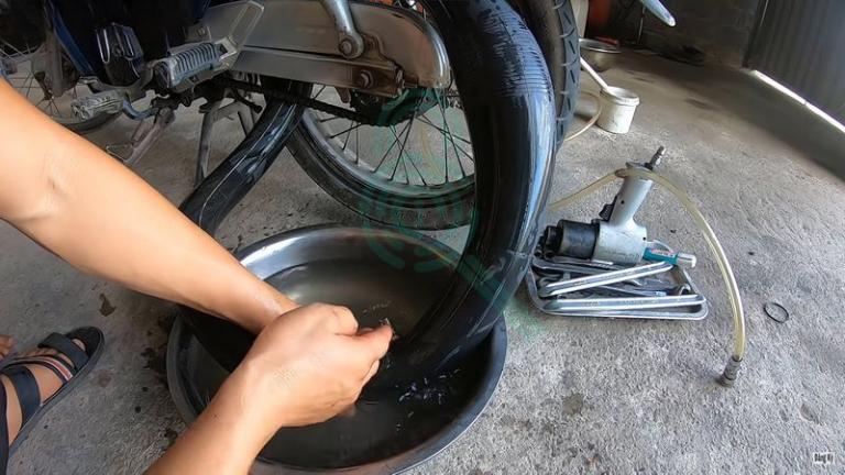 Kiểm tra lốp xe điện bằng nước để tìm vị trí thủng.
