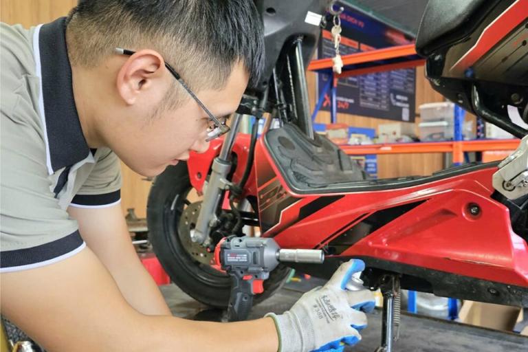Nhân viên bảo dưỡng cân chỉnh phanh và kiểm tra động cơ xe máy điện sau 6 tháng sử dụng