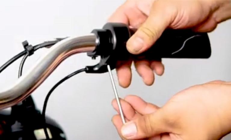 Kỹ thuật viên đang kiểm tra dây dẫn và hệ thống đèn chiếu sáng trên xe máy điện