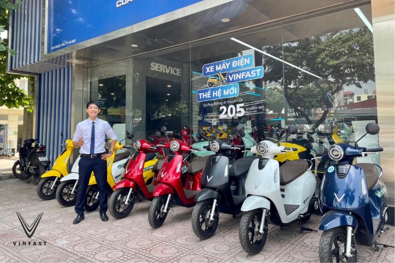 Nhân viên kiểm tra pin và phanh xe máy điện trước khi bàn giao cho khách thuê